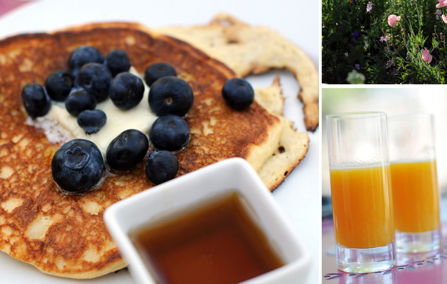 Blueberry pancakes with syrup, garden, and fresh squeezed orange juice from Cochineal
