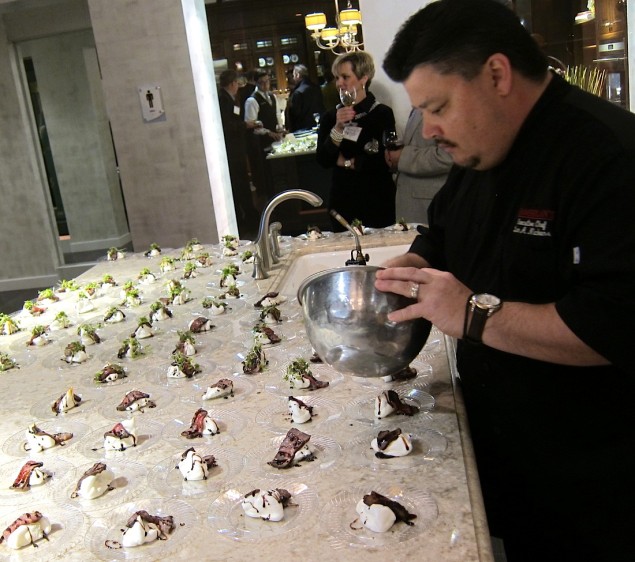 Chamberlain's Excutive Chef Lan Nickens finishes off tasting plates of Texas Pecan Balsamic roasted NY Strip with Maytag Blue Meringue Clouds and Smoked Micro Greens