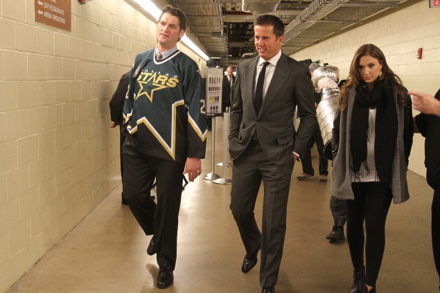 Mike Modano, his former teammate Derian Hatcher (left), and his wife Alison make their way to the rink before the ceremony.  (photo by Chris McGathey)