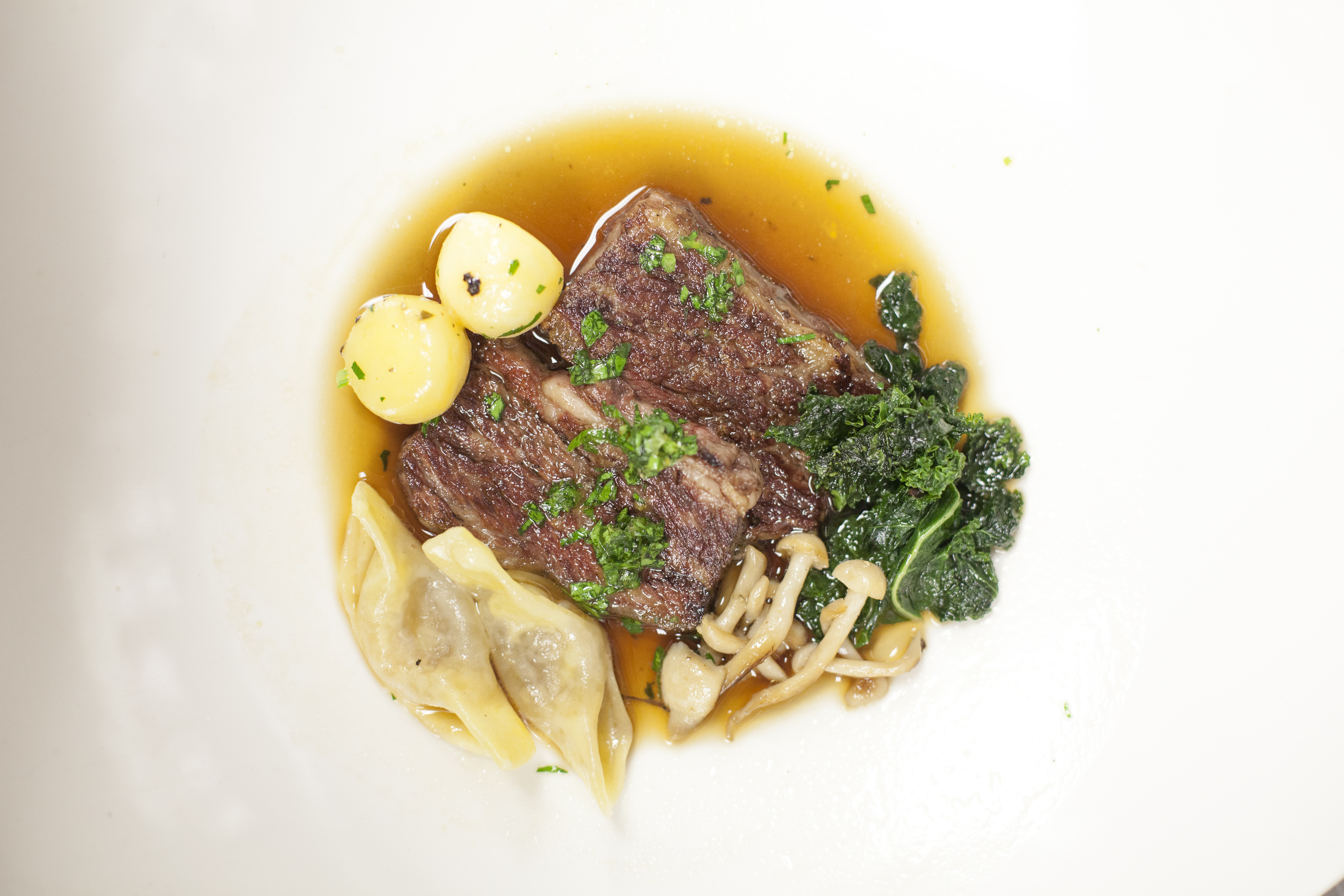 Beef Short Rib, Marrow Casoncelli, Beech Mushroom, Kale, Consommé. Photography by Kim Duffy.