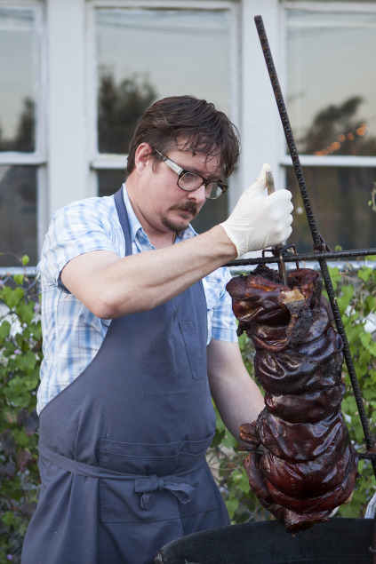 Chef Tim Byres with a whole roast suckling pig. Photo by Kim Duffy.
