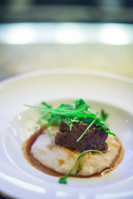 Braised beef short rib with white corn grits and arugula. Photography by Kim Duffy.