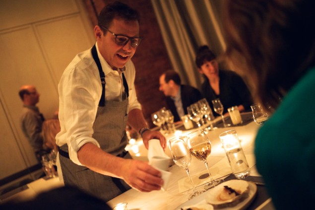 Tesar pouring warm brown butter over live scallops. Photo by Brad Murano.