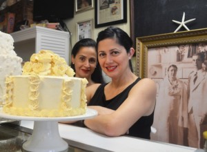 Sara Vazquez (right) and her sister, Rita (left), stand in front of a photo of their grandparents (photo by Carol Shih)