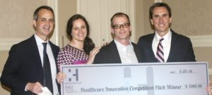 Socrates accepts a check after winning the inaugural Health Innovation Pitch Competition. (Quincy Preston/Dallas Innovates)