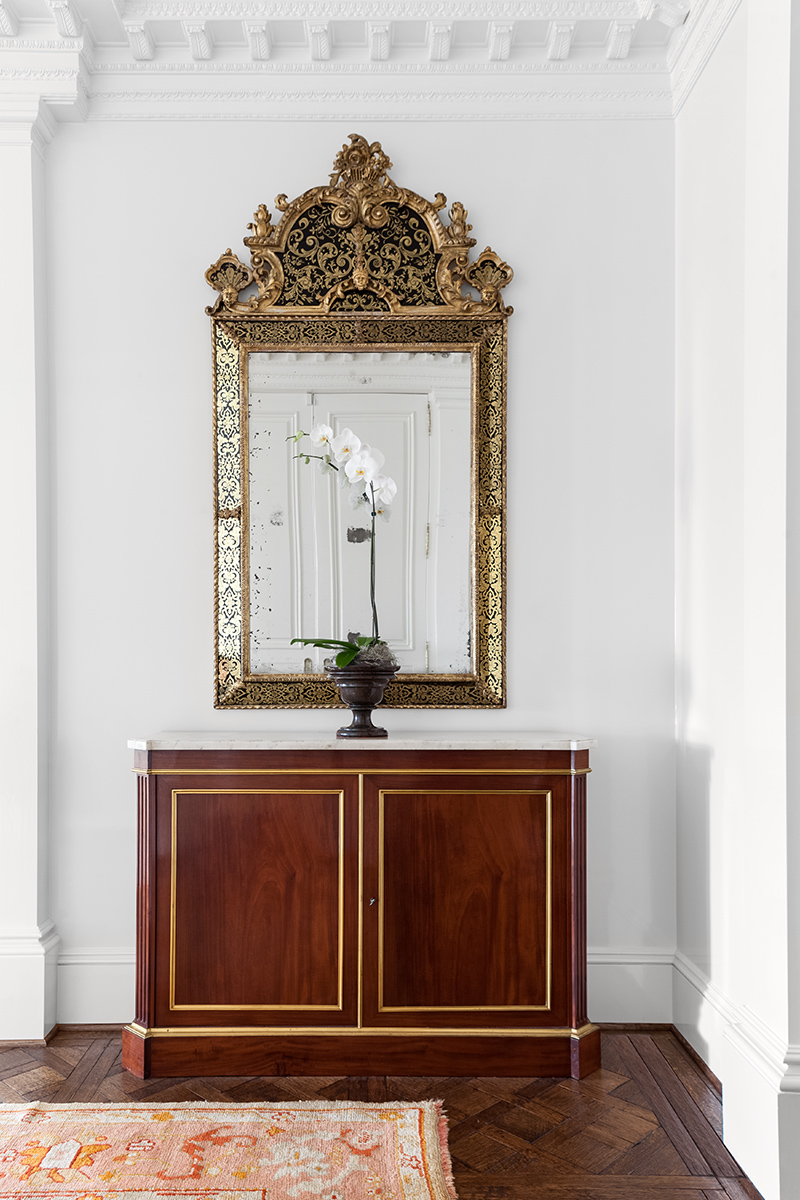 Sara’s antique cabinet and gilt mirror were repurposed in the apartment’s entryway.