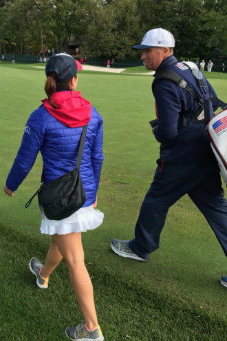 Julie Fox walking the course with Phil Mickelson's caddy, Jim "Bones" Mackay.