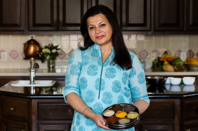 Portrait image of Indian cook Sapna in her home kitchen.