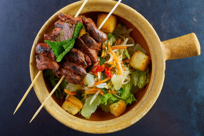 Charred duck hearts over an herb salad at Mot Hai Ba.