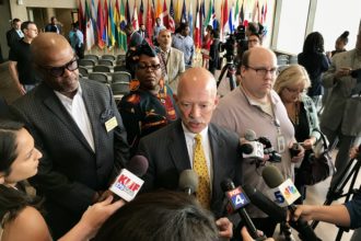 John Creuzot speaks to reporters