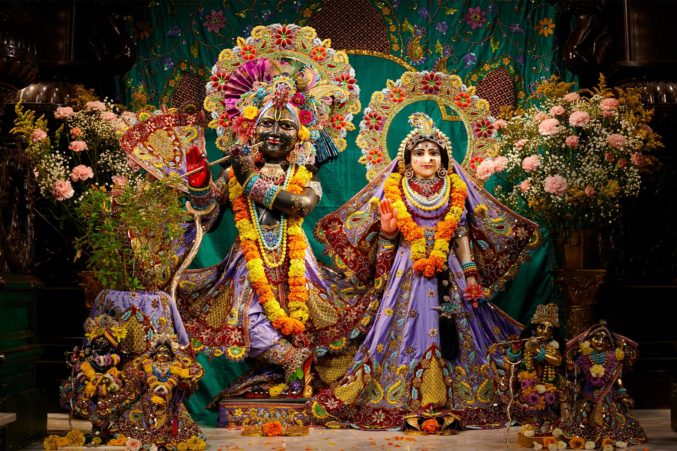 Statues of Krishna and His Female Counterpart Dressed in Purple