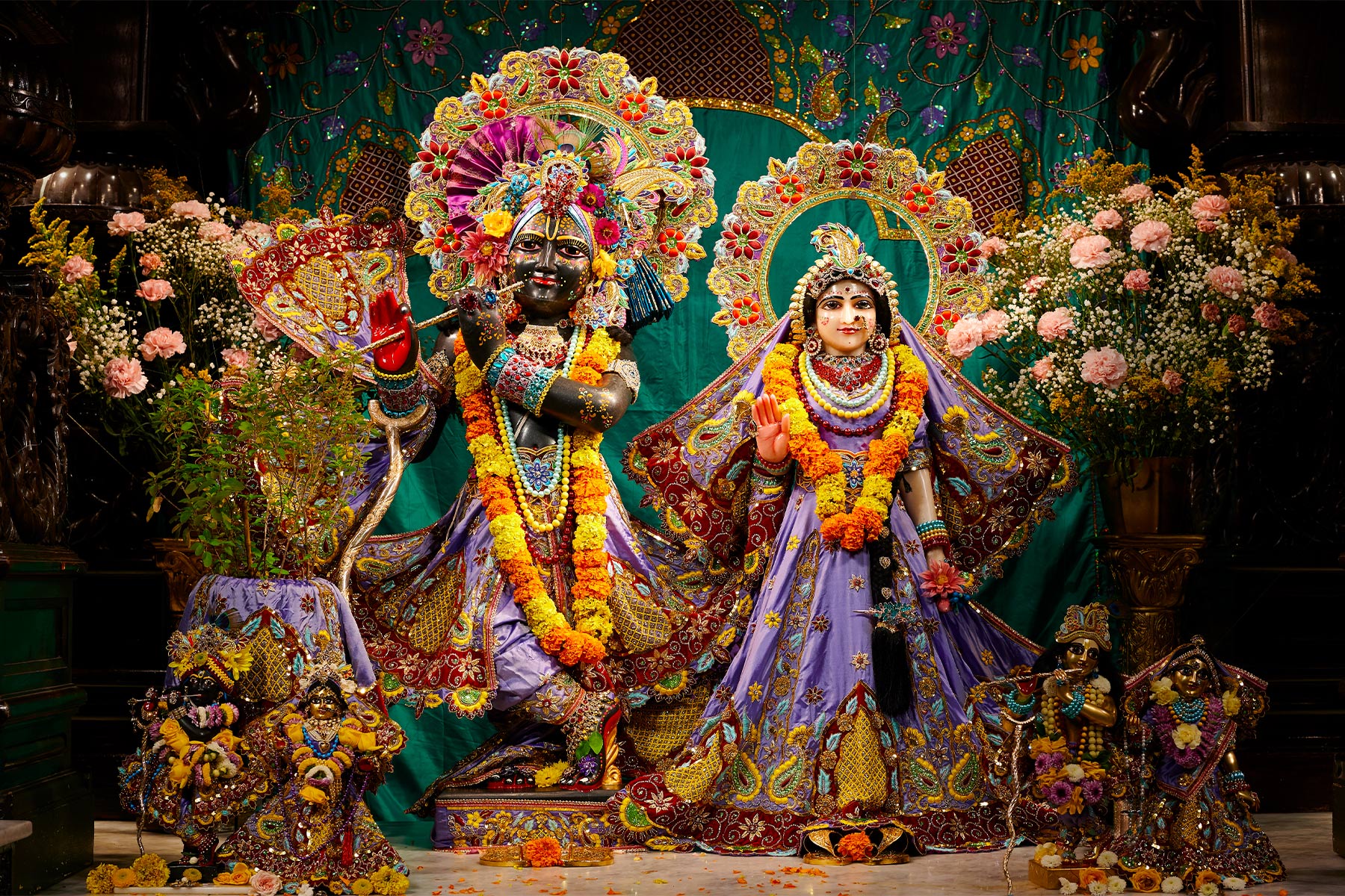 Statues of Krishna and His Female Counterpart Dressed in Purple