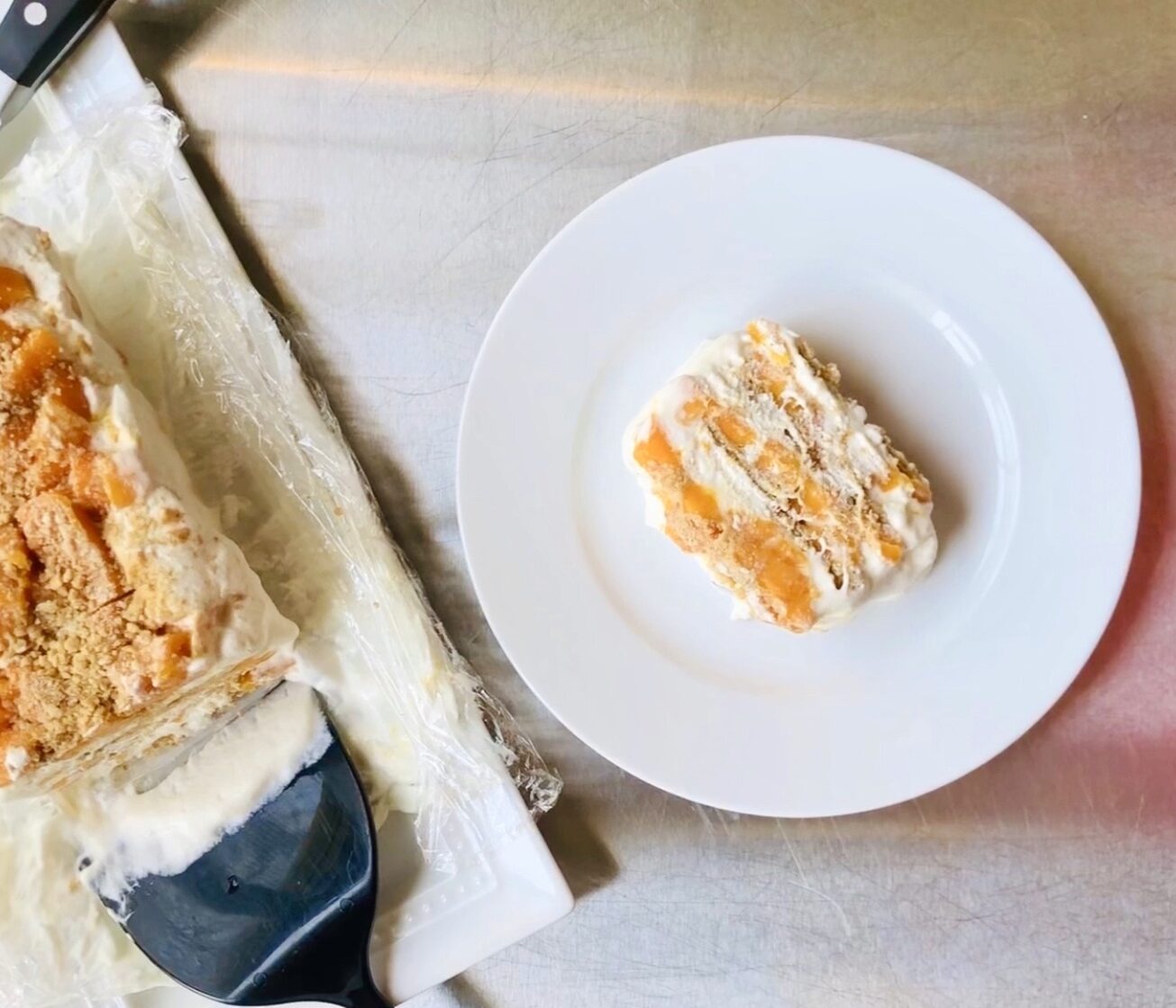 Plate with a slice of mango ice box cake.