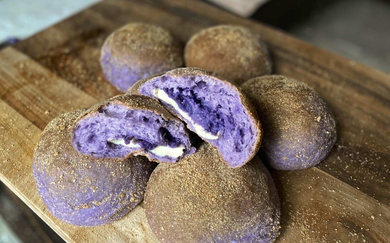 Purple Filipino bread rolls called ube pandesal with ube (aka purple yam) and sweet cheese filling.
