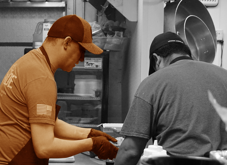 Two men working in a commercial kitchen.