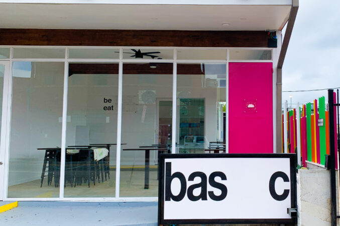 Exterior of the Basic Taco shop in Deep Ellum with neon design elements, bright pink door.