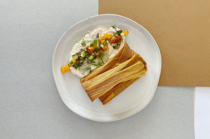 A tamale on a white plate.