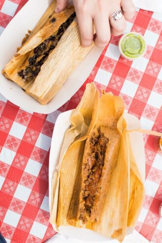 Two tamales on a picnic checkered tablecloth