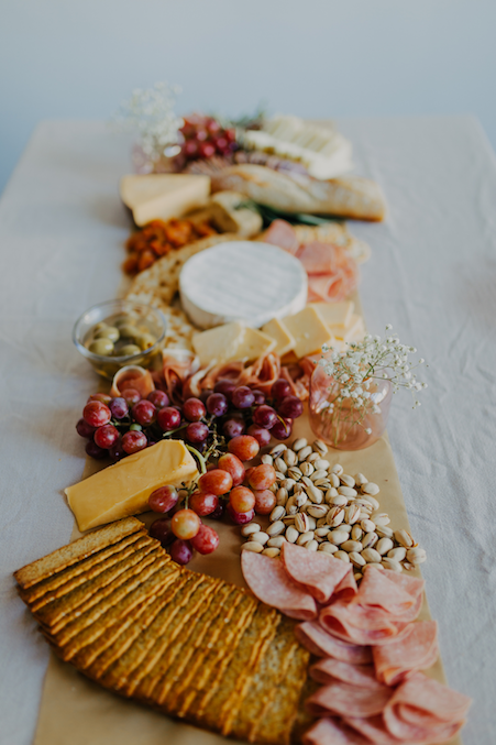 A charcuterie board of cured meats, crackers, and fruit.