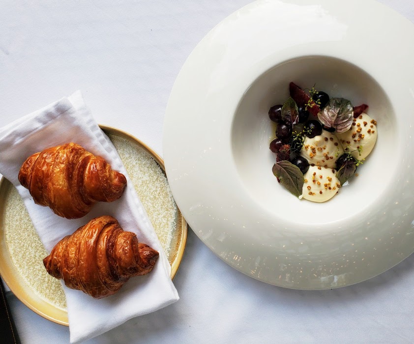 Whipped foie gras with charred grapes and smoked maple syrup alongside croissants.