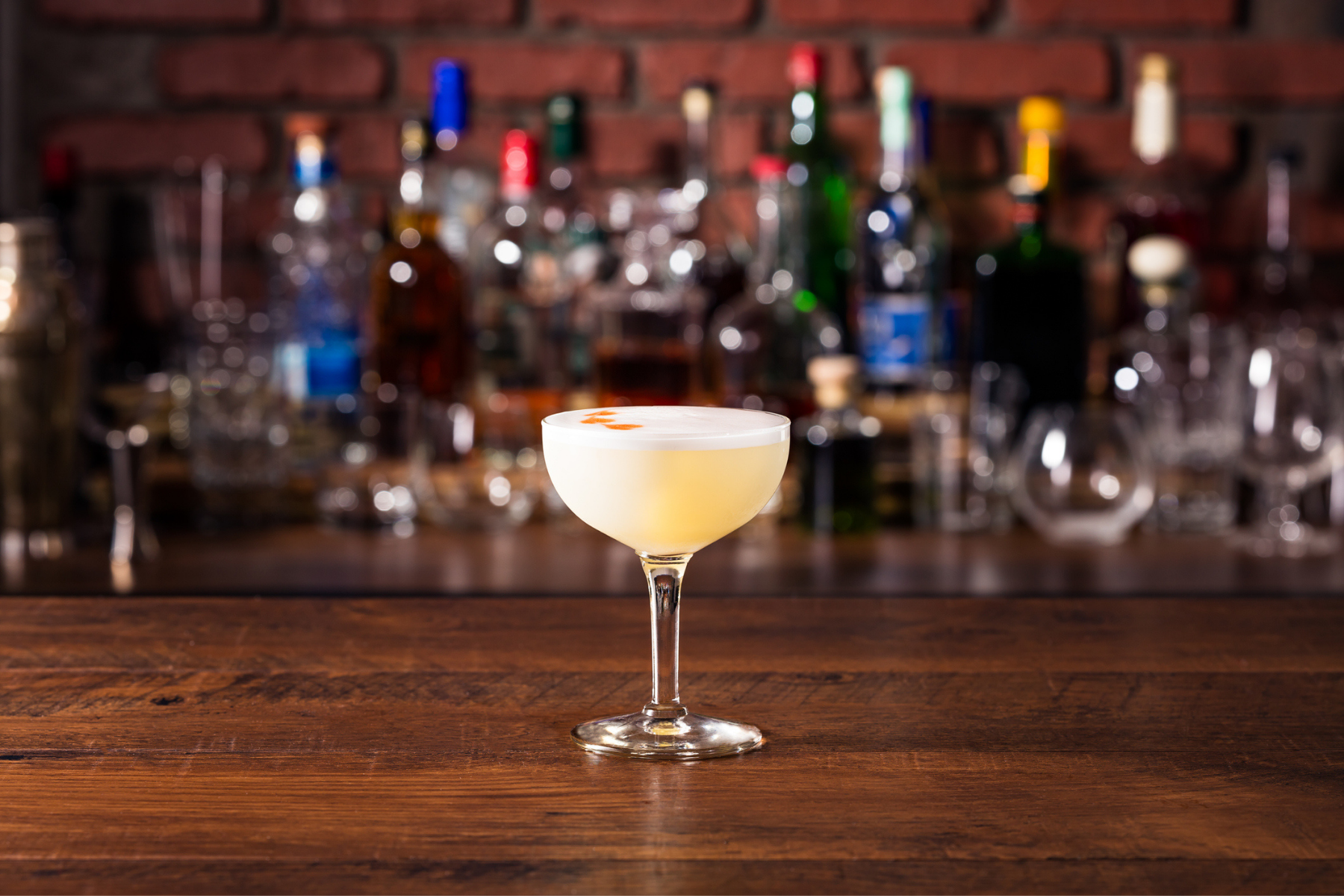 A pisco sour cocktail on a bar top.