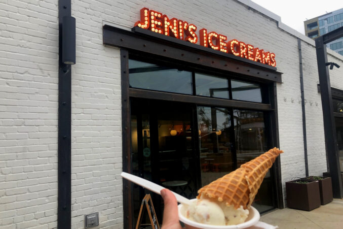 Hand holding ice cream in front Jeni's Ice Creams in Deep Ellum.