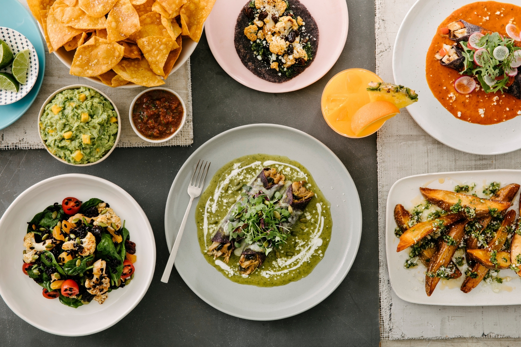 Table top spread of enchiladas, chips, and more from Lada