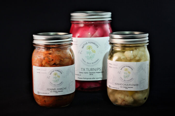 Three jars of different kinds of pickles. On the left is fennel kimchi, middle jar is pickled turnips, and third jar is pickled cauliflower.