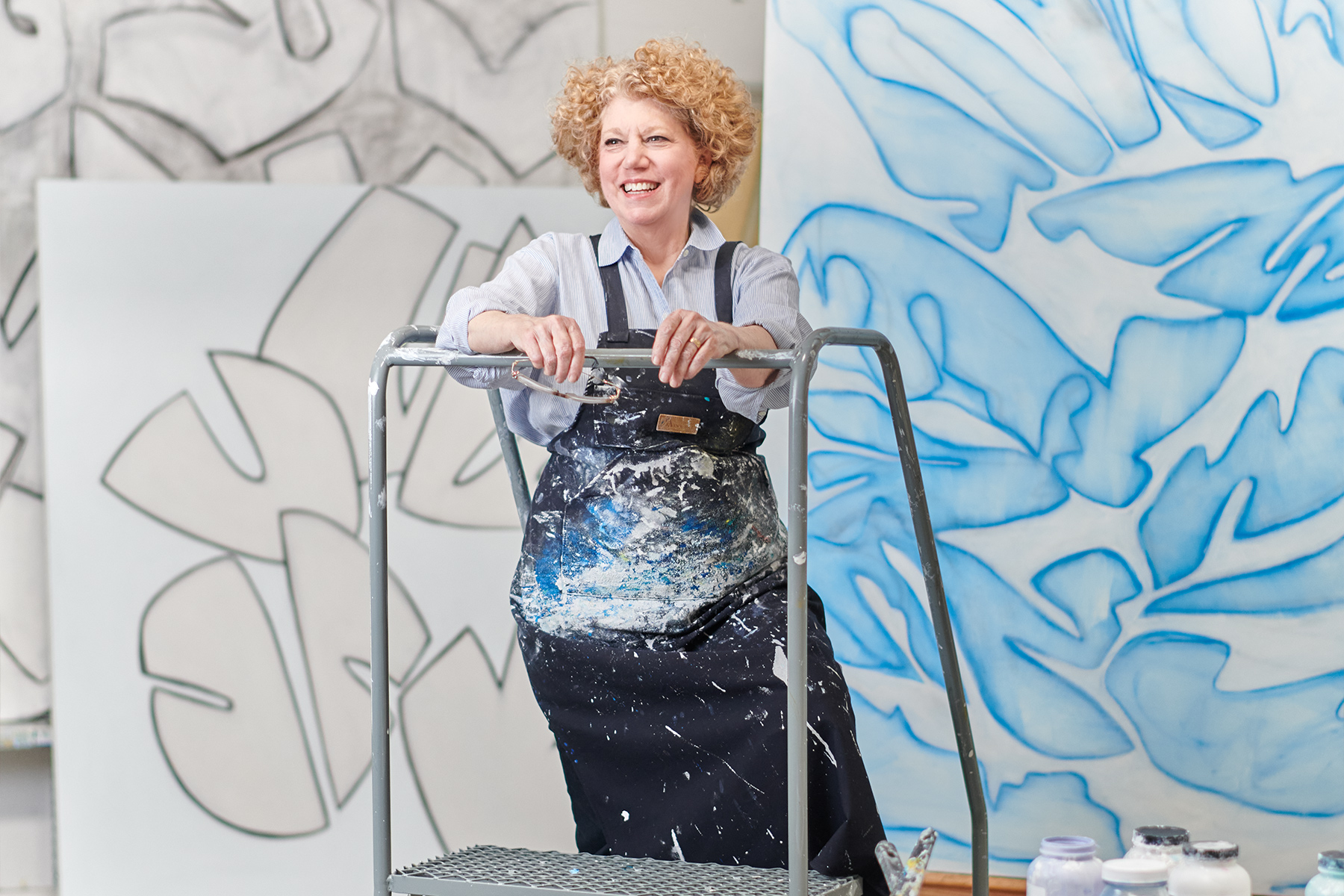 Cobie Russell standing in front of her paintings in her studio