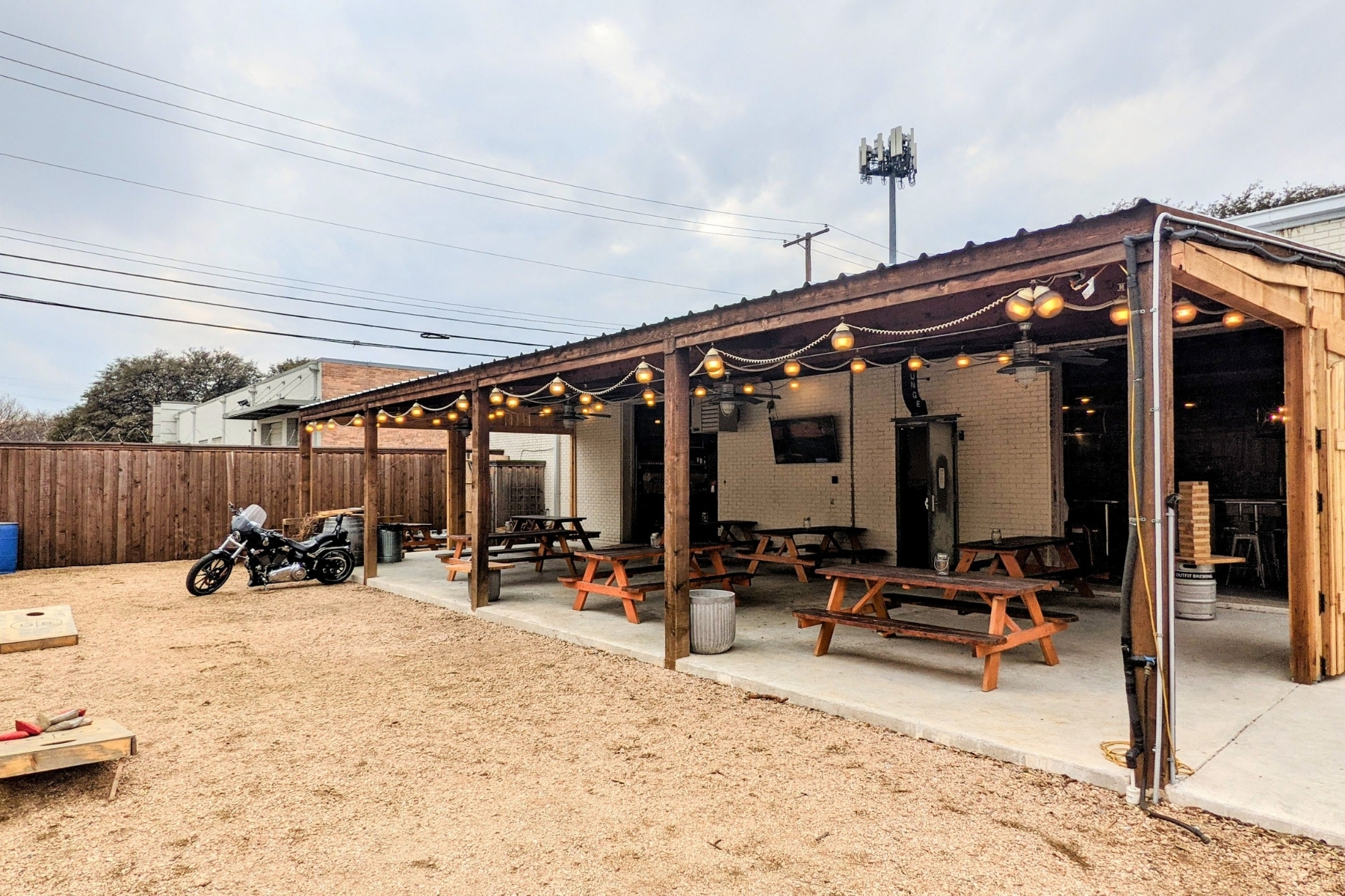 The exterior and outdoor patio space at Outfit Brewery with simple picnic tables where you can sit and sip a brew.
