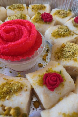 Cheese desserts decorated with bright pink frosting roses.