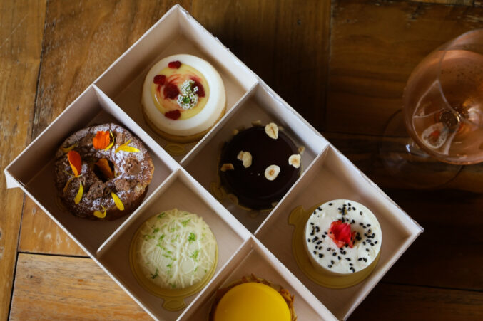 A box with six petite cakes, all different flavors like lemon-raspberry cheesecake and coconut lime.