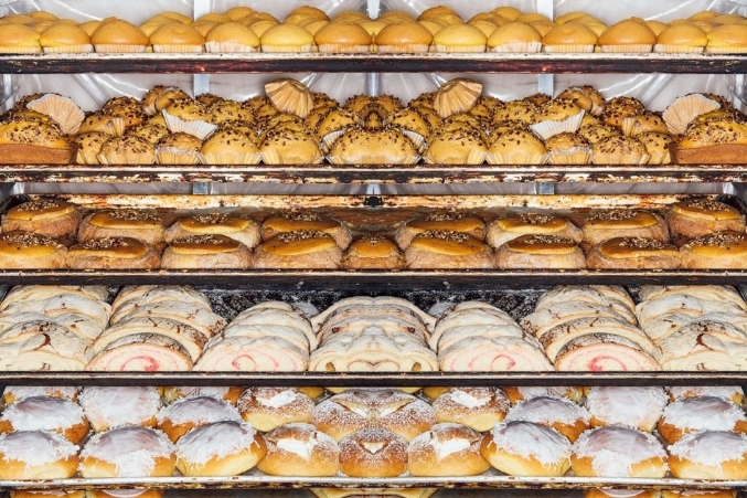 Mexican pastries and pan dulce on baking sheets on a baking rack.