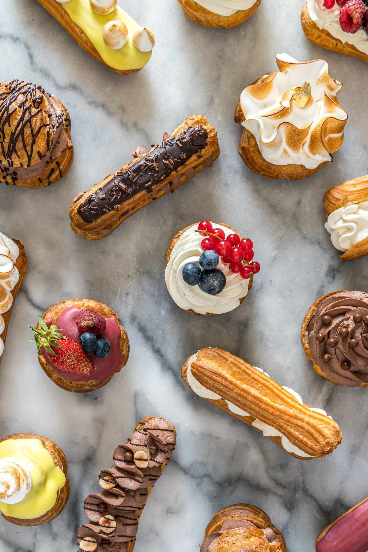A whole pastry case worth of delights on a marble table top.