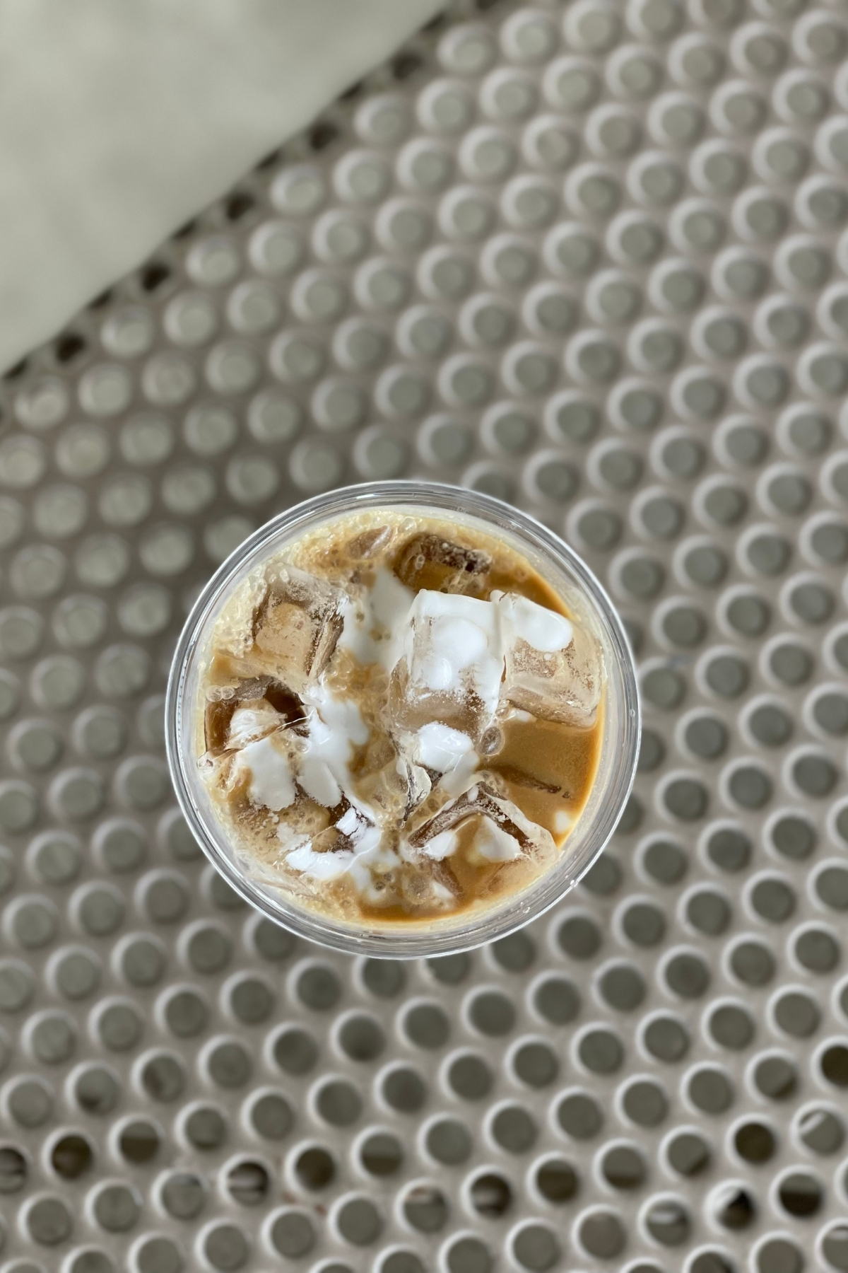 Top-down view of an iced Vietnamese coffee on top of an outdoor patio table.