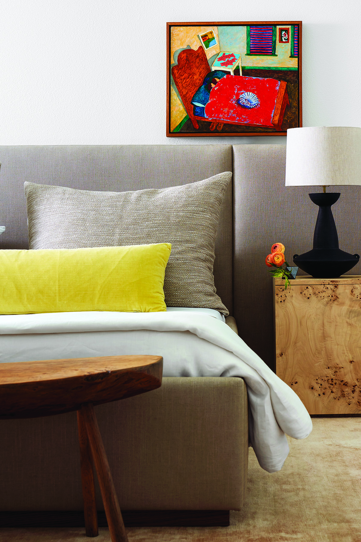 Primary bedroom with set of pillows and lamp beside on nightstand.