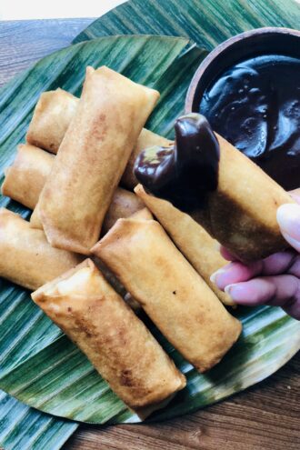 banana turon on a banana leaf with coconut chocolate sauce