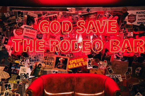Neon Sign that says “God Save the Rodeo Bar”