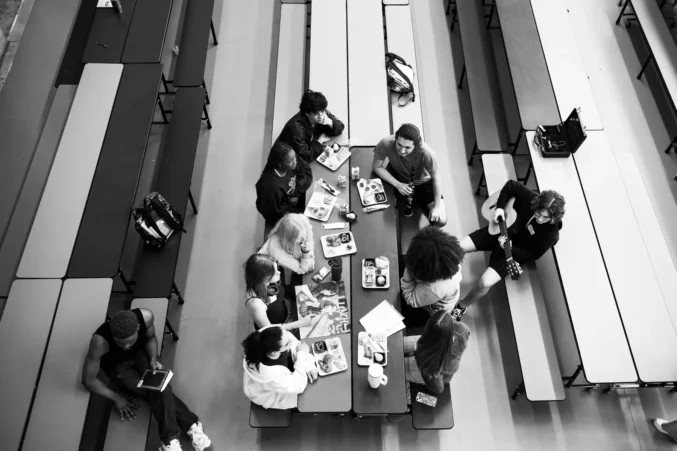 A group of students at Booker T Washington high school sit around pinic style lunch tables.