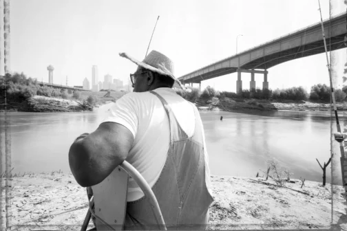 Man in a cowboy hat fishing in the Trinity River.